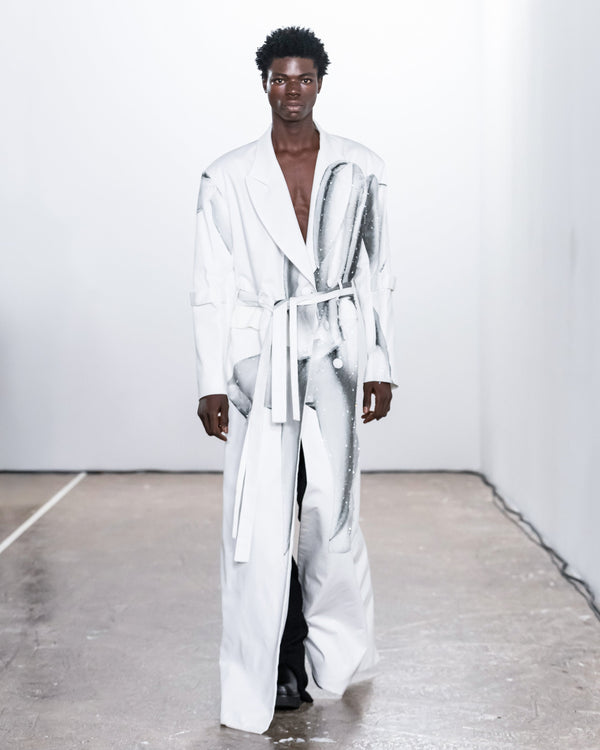 Person wearing a white robe on a plain background